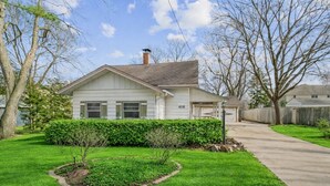 A single-story house with a garage, a well-maintained lawn, and a clear sky. - 5 Bed Home w/ Big Yard & Front Porch by Navy Base (Libertyville)