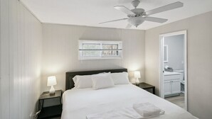 A bedroom with a bed, two bedside tables with lamps, a ceiling fan, and a window with blinds. - 5 Bed Home w/ Big Yard & Front Porch by Navy Base (Libertyville)