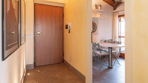 A hallway with a wooden door, a small table with chairs, and a window with curtains. - Peler House at Benaco - Style, Lake view & Pool (Toscolano Maderno)