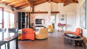 A spacious living area with a high ceiling, a dining table, and comfortable seating. - Peler House at Benaco - Style, Lake view & Pool (Toscolano Maderno)