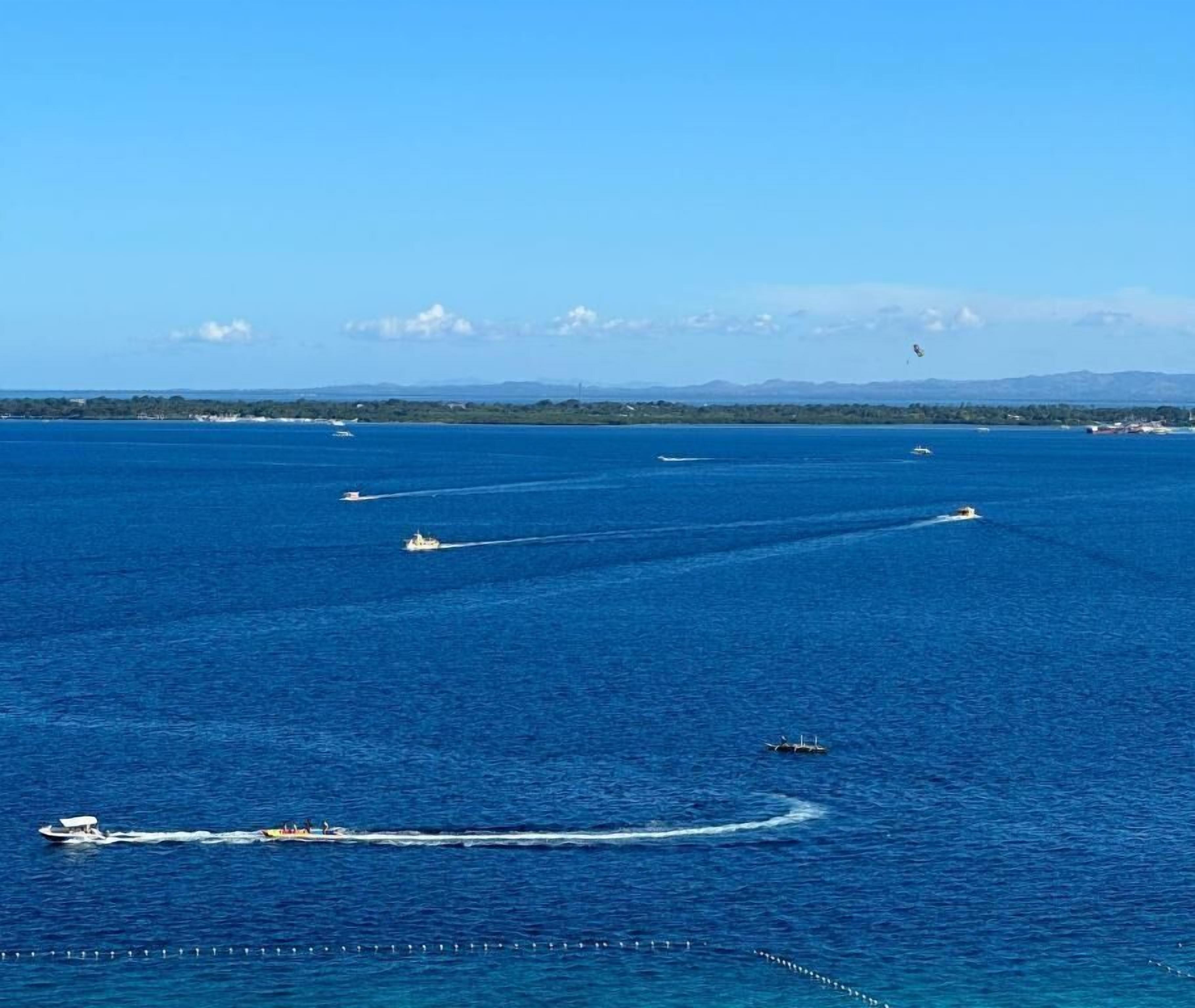 A large body of water with several boats and a distant shoreline.