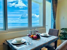 A dining table with a view of the ocean through large windows.