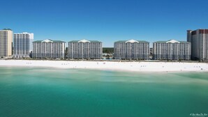 A beachfront hotel with multiple high-rise buildings, a sandy beach, and clear turquoise waters. - Beachfront Long Beach Tower IV 1205, Pools, Hot Tub, FREE Golf & Perks! (Panama City Beach)