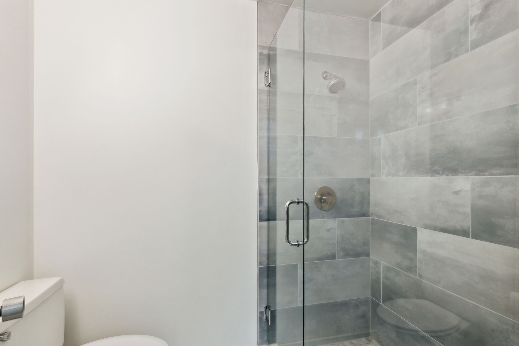 Un bagno moderno con box doccia in vetro e un water.