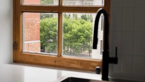 A kitchen with a window, a sink, and cabinets.