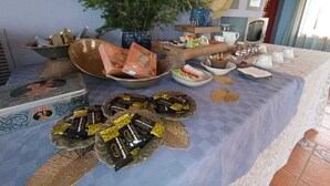 Una mesa de buffet con diferentes alimentos, una planta decorativa y una pared con carteles informativos.
