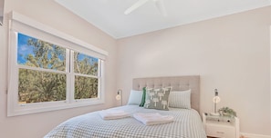 A bedroom with a bed, a nightstand, a window, and a ceiling fan. - The Rad Shack - Echuca Holiday Homes (Echuca)