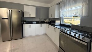 A modern kitchen with stainless steel appliances, white cabinets, and a black countertop. - Hilltop Condos Unit 3 - 1-bedroom with AC, WiFi centrally located in Gros Islet (Gros Islet)