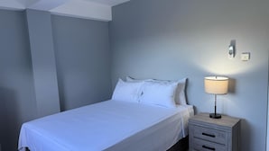 A bedroom with a bed, bedside table, lamp, and a wall-mounted phone. - Hilltop Condos Unit 3 - 1-bedroom with AC, WiFi centrally located in Gros Islet (Gros Islet)