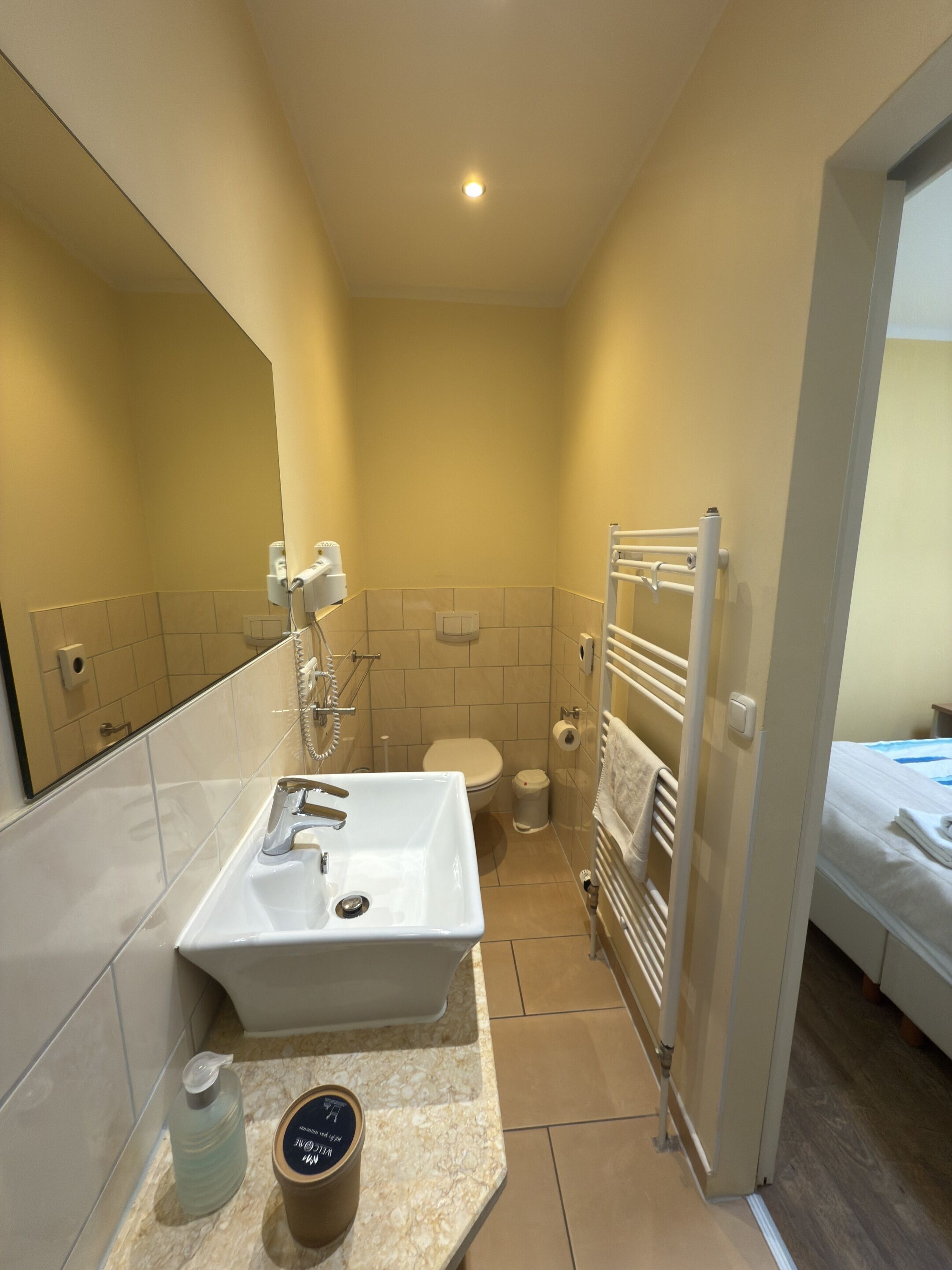 Une petite salle de bain comprenant un lavabo, des toilettes et un porte-serviettes.