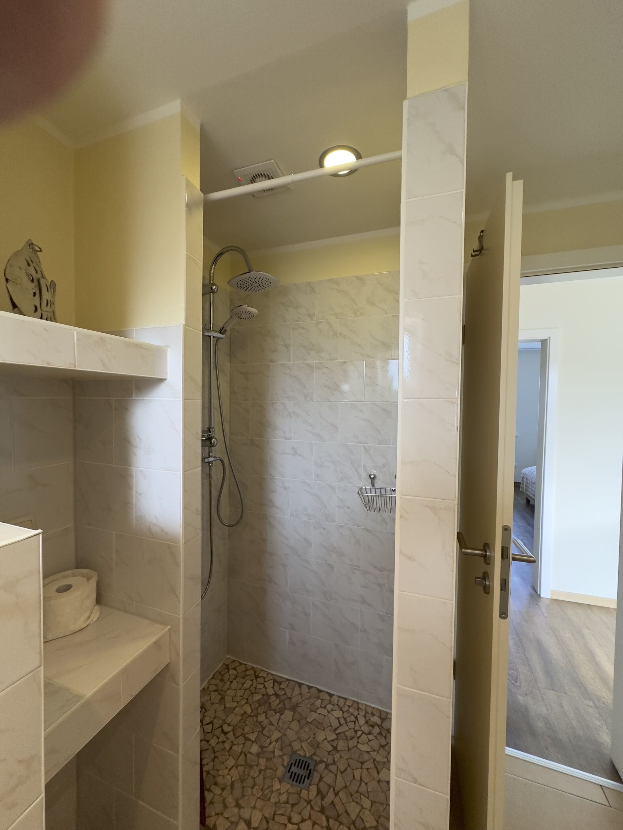 Un bagno con doccia, WC e lavandino.