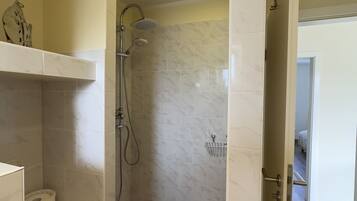 Un bagno con doccia, WC e lavandino.