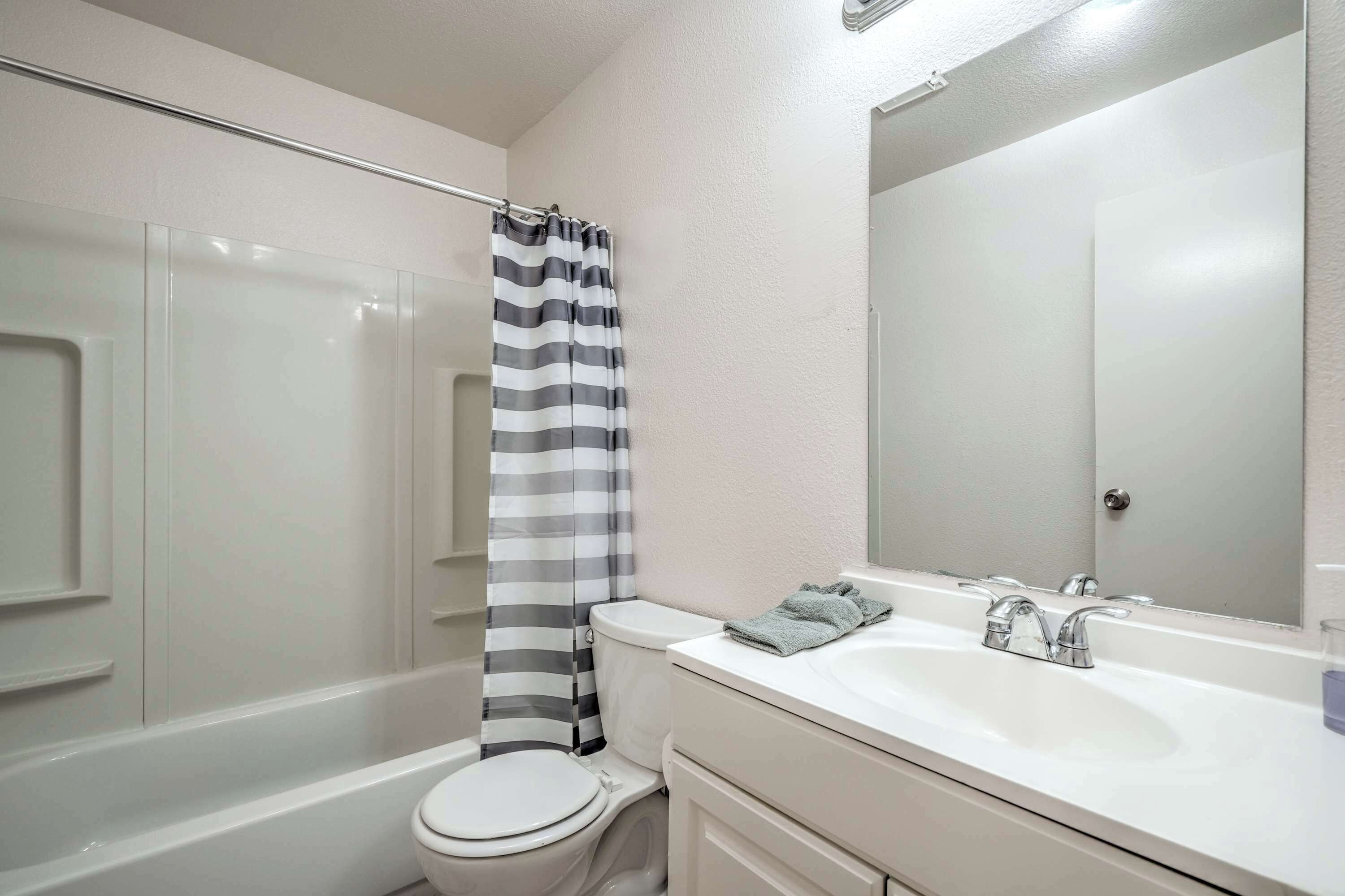 Une salle de bain avec une baignoire, des toilettes et un lavabo avec un miroir.