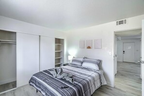 A bedroom with a bed, a wardrobe, a nightstand, and a door leading to another room. - Vegas Getaway Near Strip! Sleeps 6! (Las Vegas)