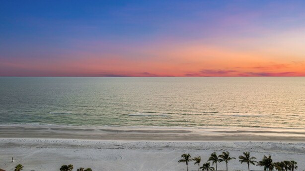 Ein Strand mit blauem Himmel und ruhiger See.