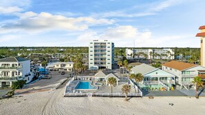 Ein Strandhotel mit Pool, mehreren Etagen und Blick auf Strand und Meer.
