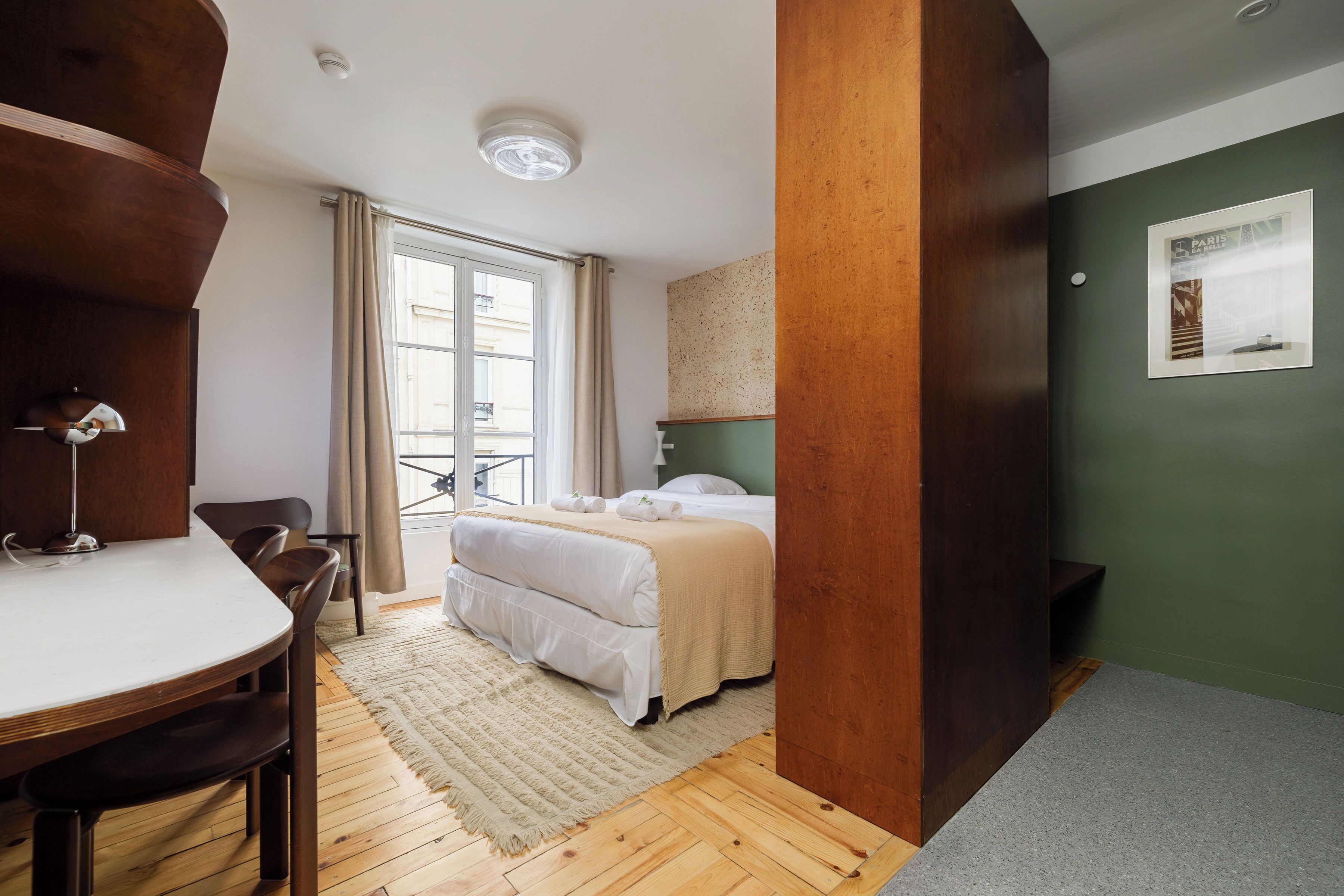 Una camera d'albergo con un letto, una scrivania e una sedia.