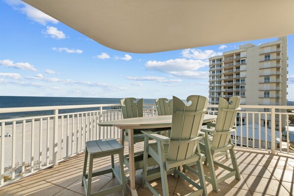 Enjoy ocean views from this balcony with a table and four chairs.