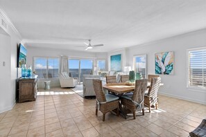 Enjoy meals at the large dining table surrounded by comfortable wicker chairs.