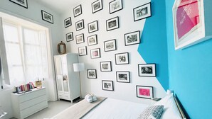 A bedroom with a bed, a wardrobe, a desk, and a wall decorated with framed pictures. - Hackert Art+Room (Caserta)