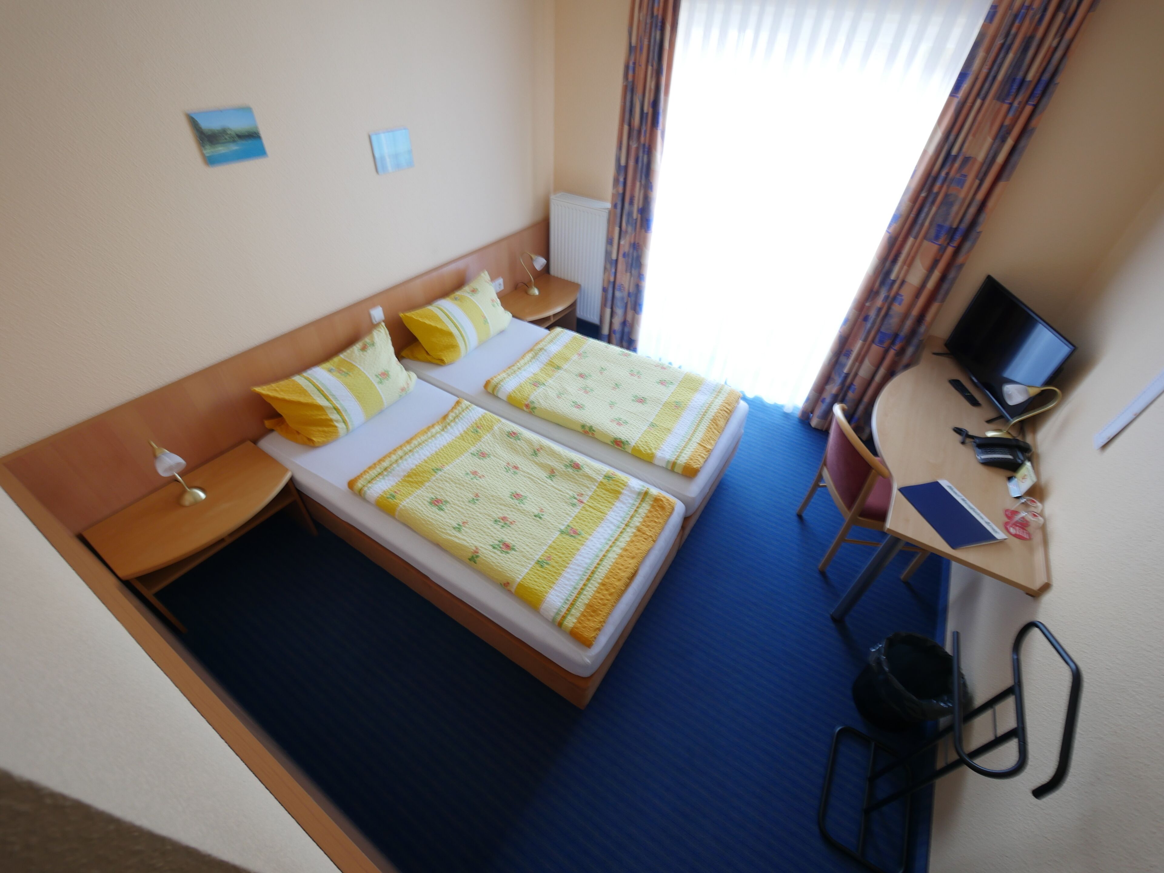 Una habitación de hotel con dos camas, un escritorio con computadora y una silla.