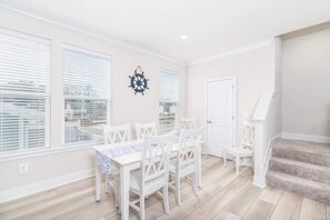 Un espace repas comprenant une table et des chaises, une porte et un escalier.