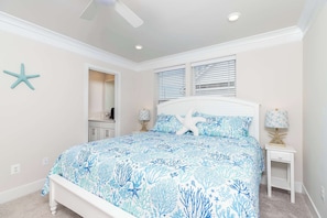 Une chambre à coucher avec un lit, des décorations en forme d’étoiles de mer et une table de chevet avec une lampe.