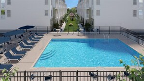 A swimming pool with lounge chairs and a small garden area. - New Townhome Steps from the Beach (Ocean City)