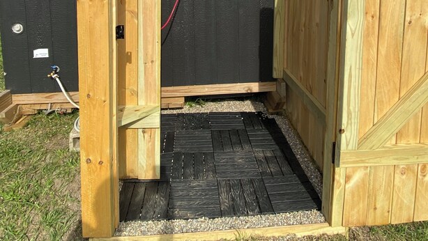 A wooden shed with a black exterior, a door, and a small window. - Peaceful, Private 1-bedroom campground in Vandalia (Vandalia)