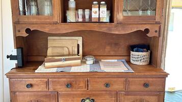 Une commode en bois, dotée de nombreux tiroirs et d’un meuble vitré contenant divers objets.