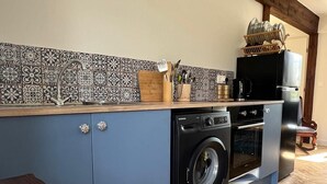 Una cocina compacta con lavadora, horno integrado y refrigerador.