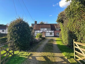 Ein Landhaus mit einem Schotterweg, der zu einer weißen Tür führt.