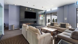 Ein modernes Wohnzimmer mit Flachbildfernseher, Sofas und Kamin.