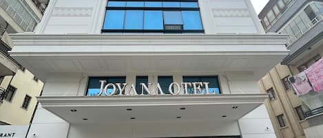 A hotel entrance with a sign reading "JOYANA HOTEL".