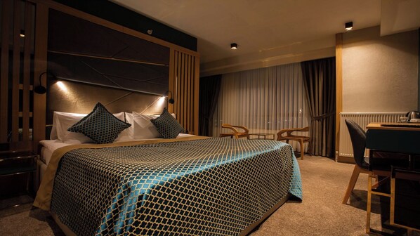 A hotel room with a large bed, a desk, and a chair. - JOYANA OTEL (Çankiri)