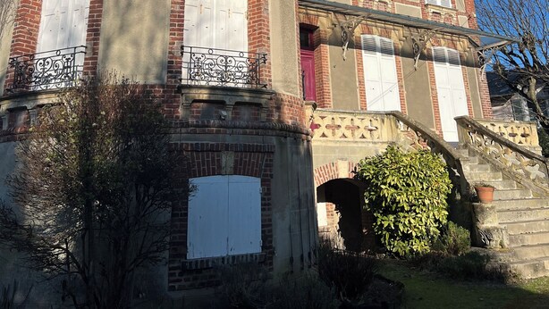 A historic building with a turret, multiple balconies, and a staircase leading to the entrance. - Cabourg fan (Cabourg)