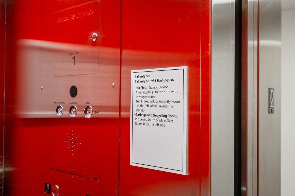 An elevator control panel with floor selection buttons and a directional sign.
