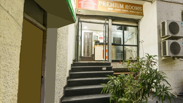 A hotel entrance with a sign for 'Premium Rooms', a staircase, and air conditioning units. - Hotel Prime Royalty Malviya Nagar (New Delhi)