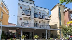 A multi-story hotel with balconies, a covered entrance, and a sign indicating a hotel and restaurant. - Hotel Laura Beach (Rimini)
