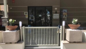 A hotel entrance with a metal gate, potted plants, and a sign indicating the hotel name. - Hotel Laura Beach (Rimini)
