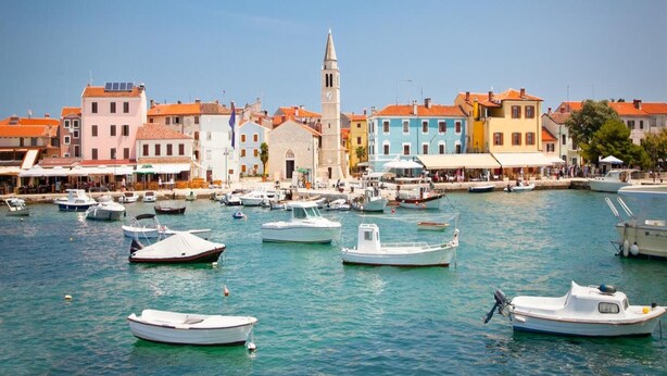 A coastal town with colorful buildings, a prominent church with a bell tower, and numerous boats docked in the marina. - Charming House With Garden and BBQ in Galizana (Vodnjan)