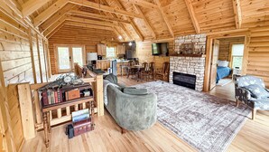 A log cabin interior with a living room, kitchen, and bedroom.