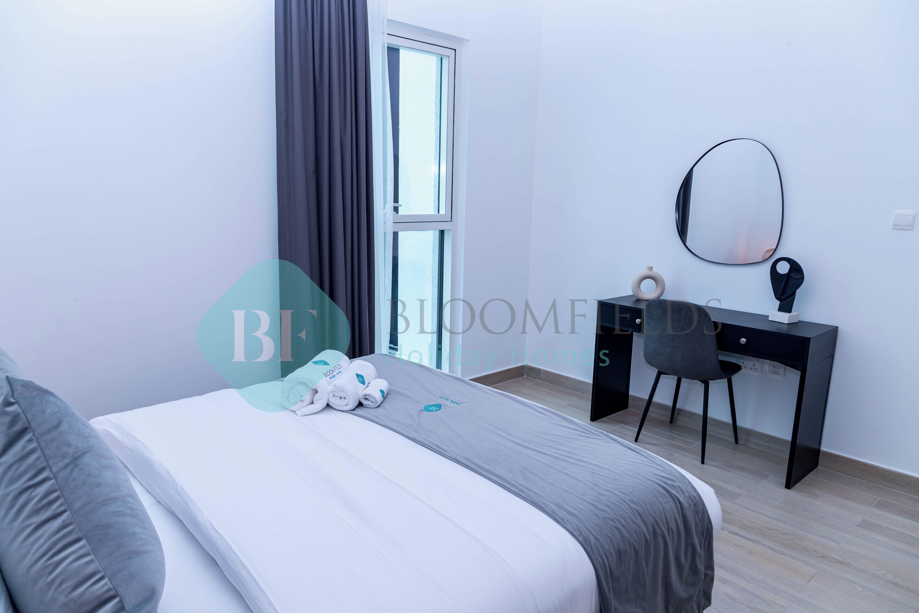 A modern bedroom with a bed, a desk, and a chair.