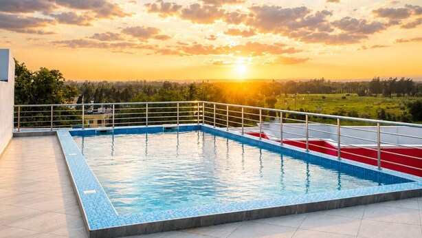 Una piscina en la azotea con vista al atardecer y al paisaje.