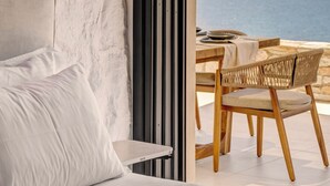 Une chambre moderne avec une grande fenêtre, un lit et une vue sur la mer.