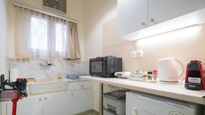 A compact kitchen with a microwave, coffee maker, and storage drawers.