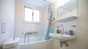 A bathroom with a toilet, a sink, a bathtub, and a shower.