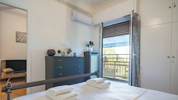 Une chambre à coucher avec un lit, une commode, un téléviseur et une fenêtre donnant sur l’extérieur.