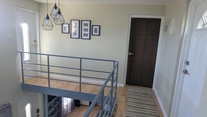 Une chambre spacieuse aménagée en loft, avec une mezzanine, une grande fenêtre et une vue sur la ville.