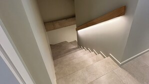 A staircase with a wooden handrail and beige tiles. - La Grange, in the heart of the village (Argelès-sur-Mer)